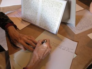 Besökares hand kopierar Elin Wägners brev i Åsa Elzens verk Medan jag försöker bli bekant med Fredrika, tänker jag jämt på dig.